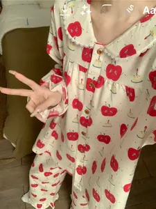 Detailed close-up of cute apple print pajamas with Peter Pan collar and lace trim