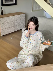 Détail de pyjama à fleurs avec bordure bleue et boutons colorés sur tissu gaufré