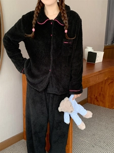 Close-up of black fleece pajamas featuring pink contrast piping and plush flannel texture