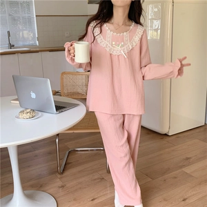 Détail du col en dentelle et de la broderie tulipe sur un pyjama rose de style rétro