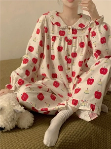Detailed view of cozy cream pajama set with apple patterns and delicate lace collar