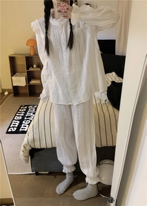 Detailed macro shot of white lace trim and vertical striped texture on pajama set
