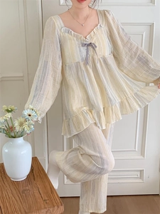 Detail of square neckline with lace trim and purple bow on striped pajama set