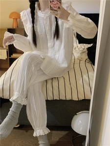Detailed view of white cotton pajama set with delicate lace trim and vertical texture