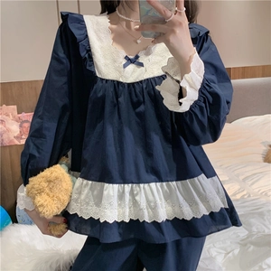 Close-up of vintage navy blue pajama set featuring white lace embroidery and satin bow