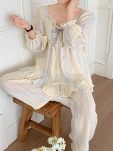Detail of pinstripe pajama set featuring ruffle neckline and purple ribbon bow