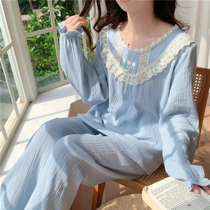 Détail de la broderie tulipe et bordure en dentelle sur pyjama en gaze de coton