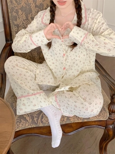 Détail d'un pyjama à fleurs roses avec col à carreaux et boutons sur tissu en crêpe de coton