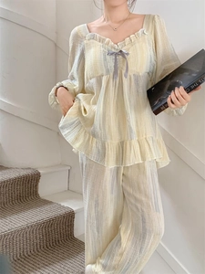 Detail of elegant ruffled square neckline with grey ribbon bow on yellow striped loungewear