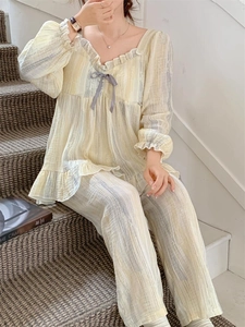 Close-up of women's yellow striped pajama set with ruffled collar and purple bow