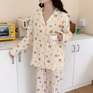 Close-up of long-sleeved beige pajamas featuring cute bear and cloud pattern prints