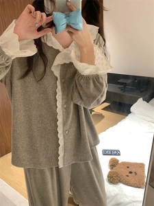 Détail du pyjama en polaire grise avec col en dentelle blanche et boutons décoratifs