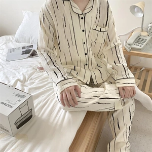 Detail of men's striped pajama set with lapel collar and chest pocket in a cozy setting