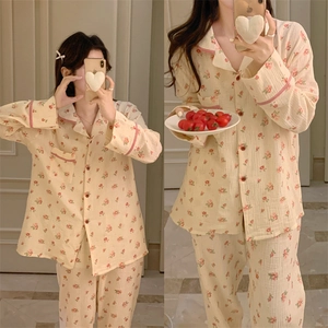 Détail d'un pyjama à fleurs à manches longues en coton crêpé avec passepoil rouge