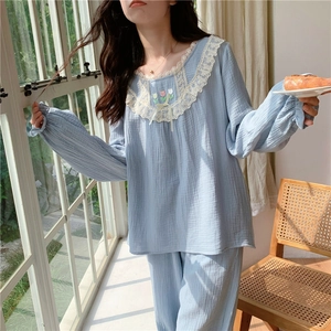 Détail du col de pyjama bleu clair avec bordure en dentelle blanche et broderie florale