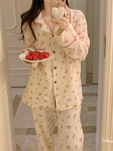 Détail d'un pyjama en coton à fleurs avec bordure rouge dans un cadre intérieur doux