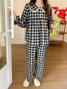 Detail von Gingham-Schlafanzug mit Spitzenkragen und Rüschenmanschetten zu Hause