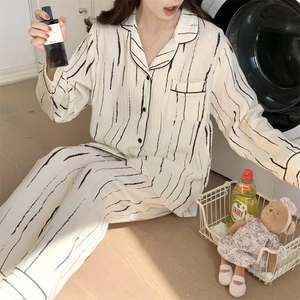 Detail of cream-colored crinkle fabric pajamas with irregular black vertical stripes