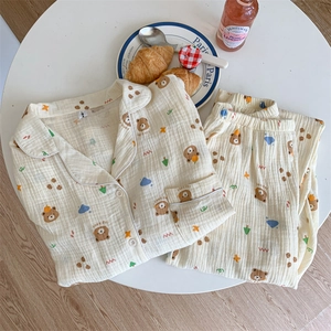 Close-up of cotton pajama set featuring cartoon bears and croissants on textured gauze fabric