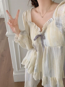 Detail of square neckline with purple bow and ruffled edges on striped pajama top