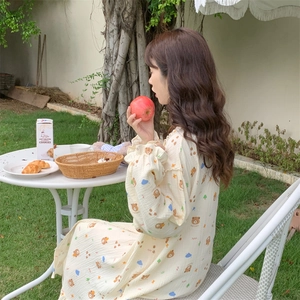 Detail of cute bear print on long-sleeve yellow pajamas with frill cuff and soft texture