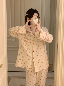Détail du pyjama à fleurs avec passepoil rouge sur le revers et les poignets