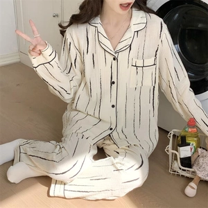 Detailed close-up of textured cotton fabric with black stripes on a cream pajama set