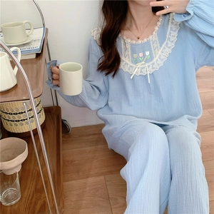 Détail de l'encolure ronde en dentelle et broderie de tulipes sur le pyjama en coton bleu