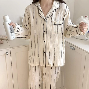 Detail of minimalist black and white striped cotton pajama set with button-up top