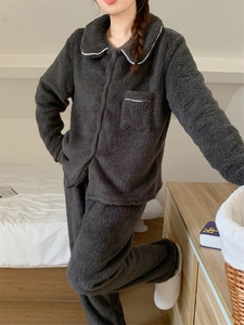 Detailed close-up of dark grey plush pajamas showing contrast piping and soft coral fleece texture