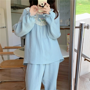 Détail de pyjama en coton bleu clair avec col en dentelle blanche et broderie tulipe