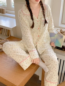 Détail d'un pyjama à fleurs roses avec bordure à carreaux et boutons en seersucker