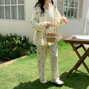 Detail of long-sleeved bear print pajama set with ruffled cuffs in an outdoor garden