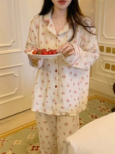 Détail du pyjama en coton à fleurs avec passepoil rouge dans un décor intérieur douillet