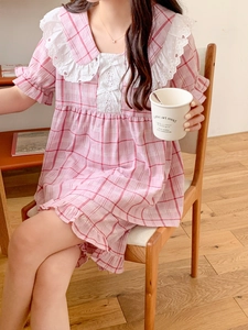 Detail of pink plaid sleepwear featuring lace ruffled collar and bow tie decorations