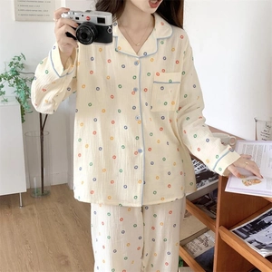 Détail d'un pyjama à pois avec col à revers contrasté bleu et une petite poche poitrine