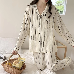 Detail of black vertical stripes on cream pajama set with lapel collar and chest pocket