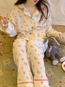 Détail du pyjama à fleurs avec passepoil à carreaux rouges et fermeture boutonnée devant