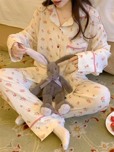 Détail du pyjama floral avec passepoil à carreaux rouges sur le col et la poche