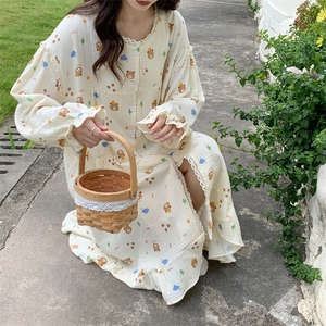Close-up of bear pattern print and lace trimmings on beige long-sleeve cotton nightgown