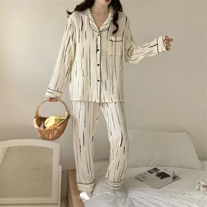 Detail of soft beige striped pajama set with textured fabric and button-down collar