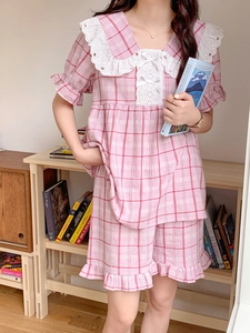 Detail of pink plaid pajama set with intricate white floral lace collar and bow