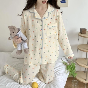 Détail d'un pyjama jaune à manches longues avec pois colorés et liseré bleu élégant