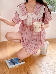 Detail of pink plaid pajama dress with white lace doll collar and ribbon bow