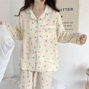 Détail d'un ensemble pyjama crème avec des pois colorés et un passepoil bleu clair