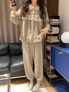 Détail d'un pyjama à col de poupée avec dentelle blanche et nœud sur tissu peluche beige