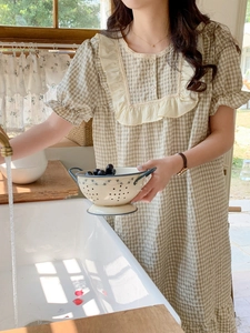 Détail du col en dentelle et motif vichy vert sur une chemise de nuit d'été douce