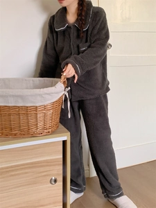 Detail view of cozy dark gray flannel pajama set featuring soft fleece and white piping