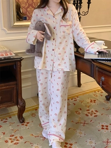 Détail d'un pyjama en coton floral avec motifs roses et bordures à carreaux roses