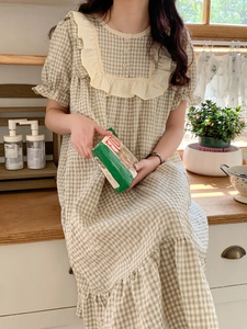 Détail d'une robe en vichy avec col volanté, manches bouffantes et bordure en dentelle
